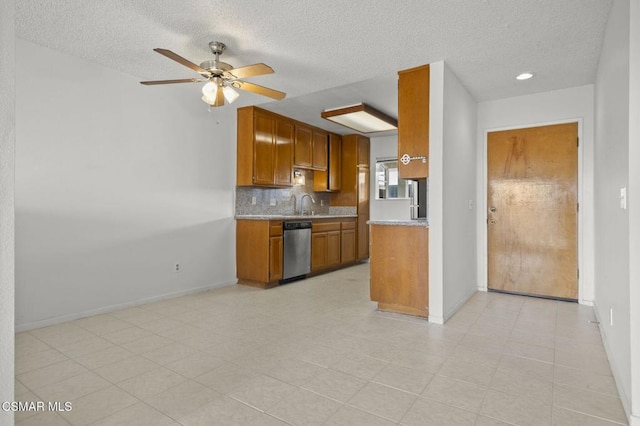 kitchen featuring stainless steel dishwasher, backsplash, sink, and ceiling fan