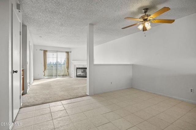 unfurnished living room featuring light carpet, ceiling fan, and a tile fireplace