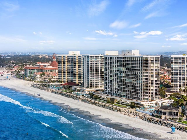 birds eye view of property with a water view and a beach view