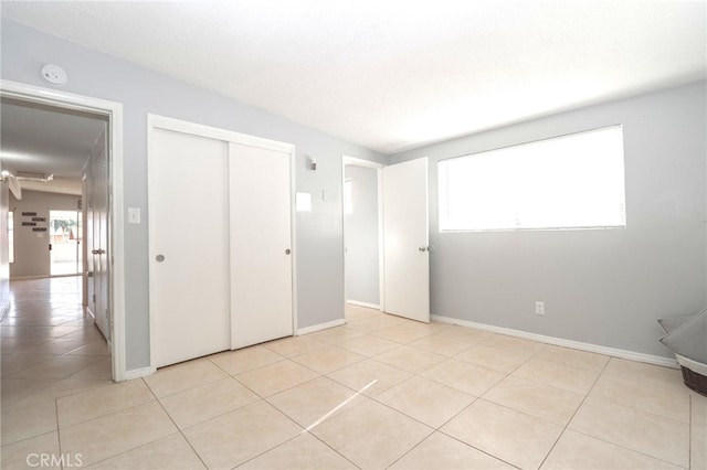 unfurnished bedroom featuring a closet and light tile patterned flooring