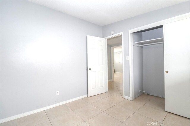 unfurnished bedroom featuring a closet and light tile patterned flooring