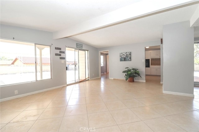 spare room featuring light tile patterned flooring and vaulted ceiling with beams