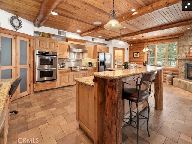 kitchen featuring pendant lighting, wall chimney exhaust hood, log walls, stainless steel appliances, and beam ceiling