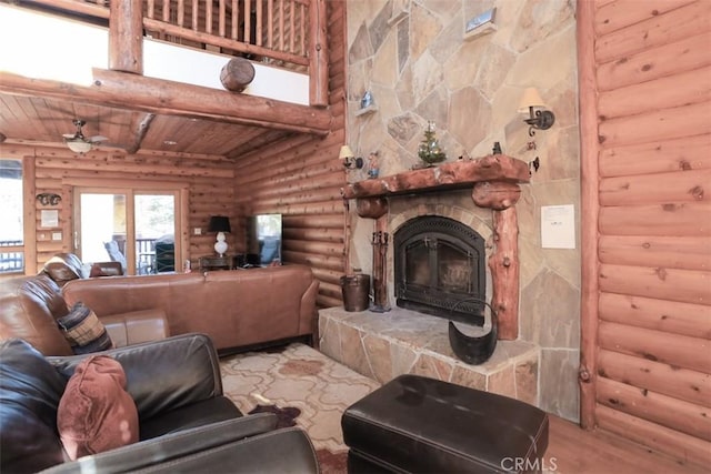 living room featuring ceiling fan, a stone fireplace, log walls, and wood ceiling