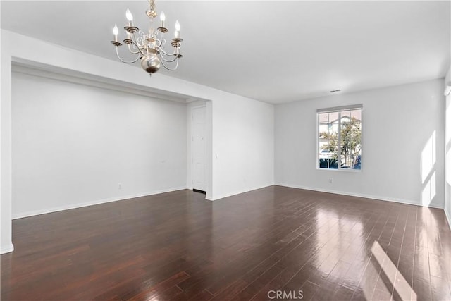 unfurnished room with dark hardwood / wood-style floors and a chandelier