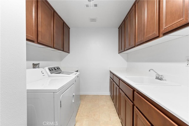 laundry room with cabinets, separate washer and dryer, and sink