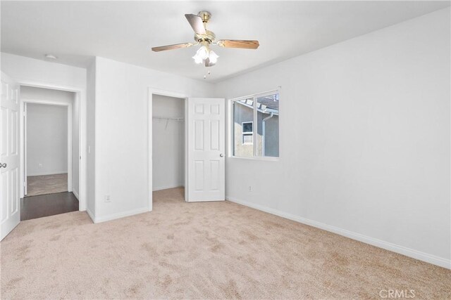 unfurnished bedroom with light carpet, ceiling fan, and a closet