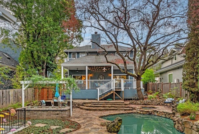 rear view of property featuring a deck and ceiling fan