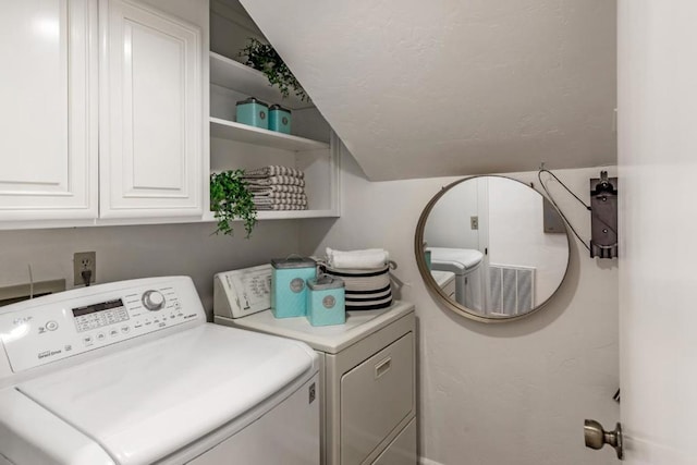 laundry room featuring cabinets and separate washer and dryer