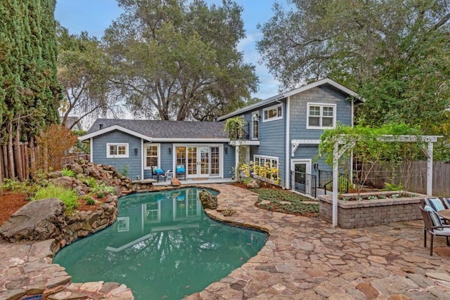 view of swimming pool with an outbuilding, a pergola, a patio area, and french doors