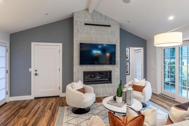 living room with hardwood / wood-style flooring, a fireplace, and vaulted ceiling with beams