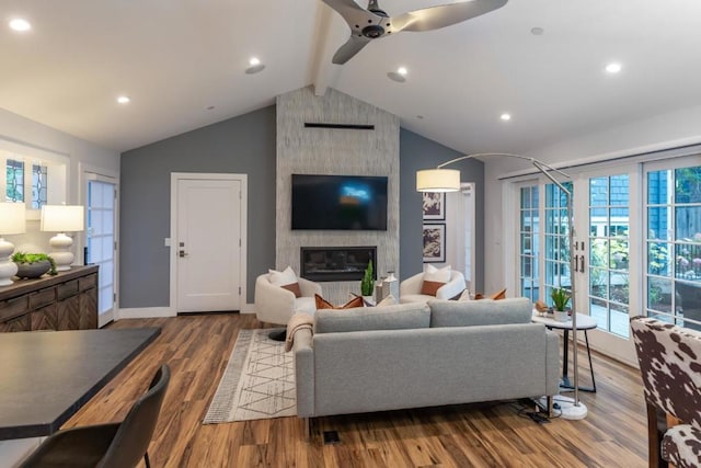 living room with wood-type flooring, vaulted ceiling with beams, ceiling fan, and a fireplace