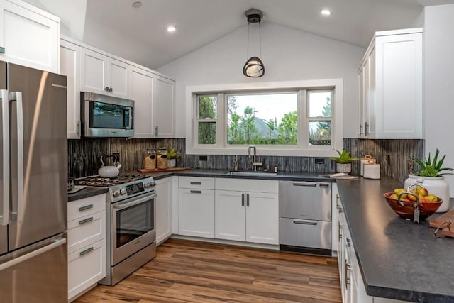 kitchen featuring decorative light fixtures, white cabinetry, sink, stainless steel appliances, and dark wood-type flooring