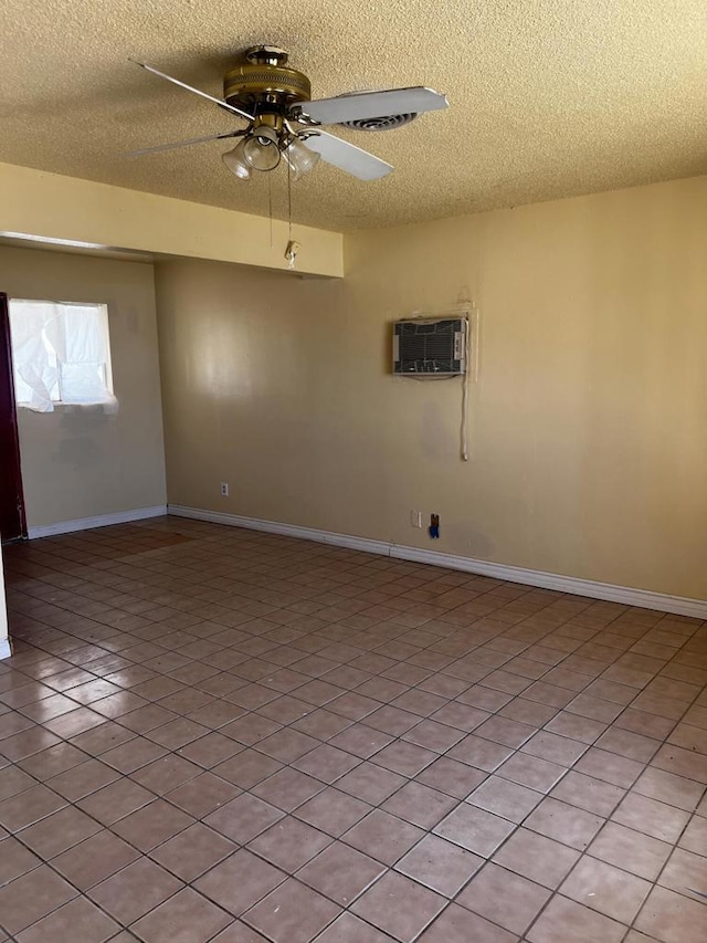 tiled empty room featuring a textured ceiling, ceiling fan, and an AC wall unit