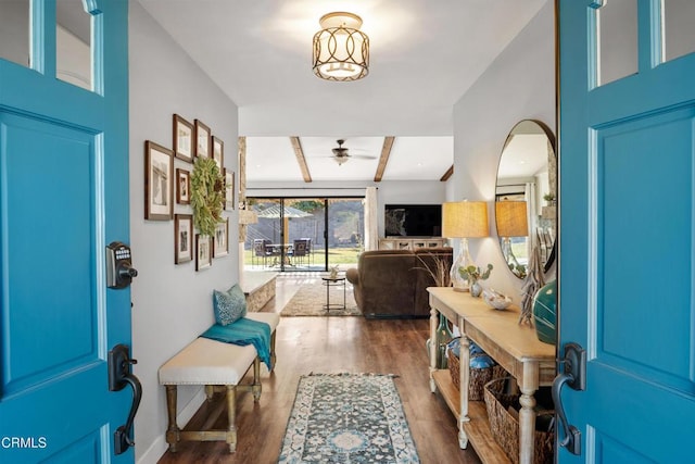 foyer entrance featuring beamed ceiling, ceiling fan, and dark wood-type flooring