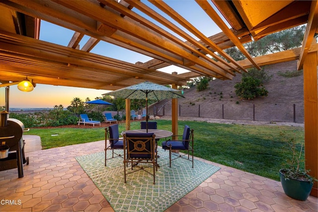 patio terrace at dusk with a lawn and a pergola