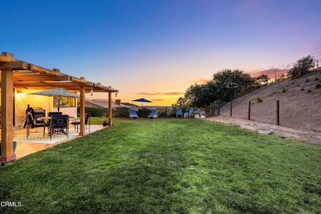 yard at dusk featuring a pergola and a patio area