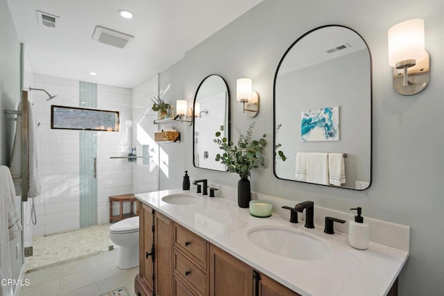 bathroom featuring tile patterned flooring, vanity, toilet, and a shower with door