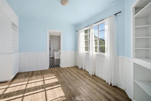 empty room featuring light wood-type flooring and built in features