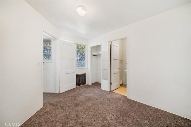 unfurnished bedroom with light colored carpet and connected bathroom