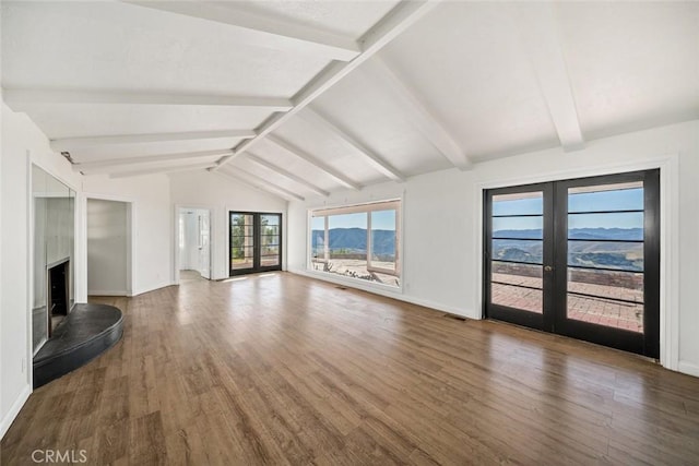 unfurnished living room with wood-type flooring, lofted ceiling with beams, and french doors