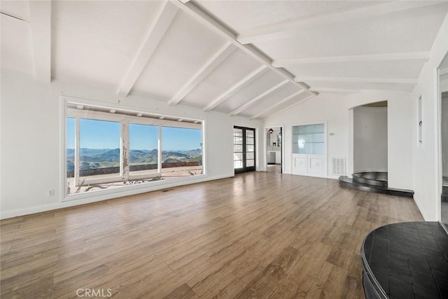 living room with a mountain view, hardwood / wood-style floors, and lofted ceiling with beams