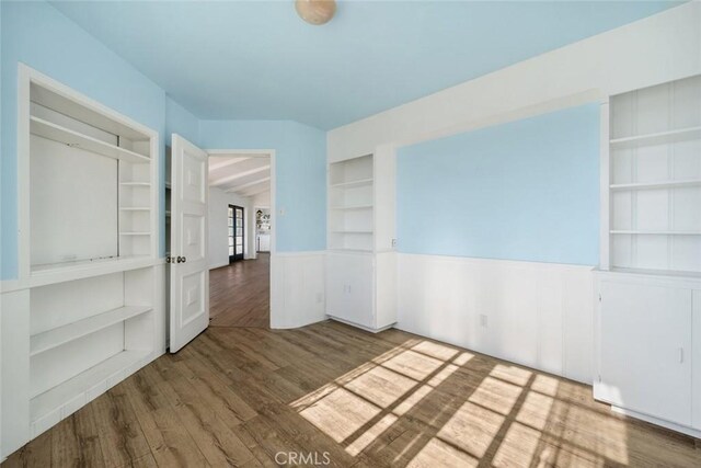 unfurnished room with vaulted ceiling and wood-type flooring