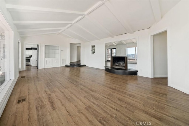 unfurnished living room with built in shelves, dark hardwood / wood-style flooring, and lofted ceiling with beams