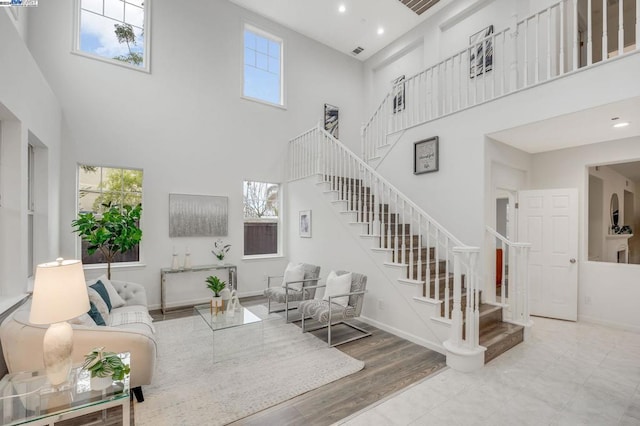 living room featuring a towering ceiling and light hardwood / wood-style flooring