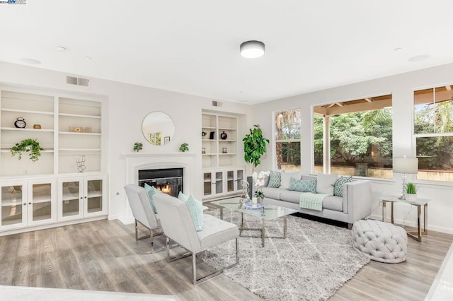 living room featuring built in features and hardwood / wood-style floors