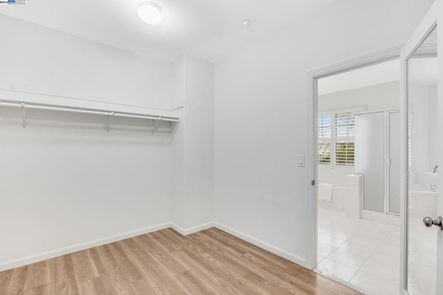 walk in closet with light hardwood / wood-style floors