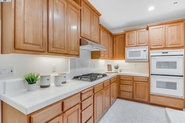 kitchen with tile countertops and white appliances