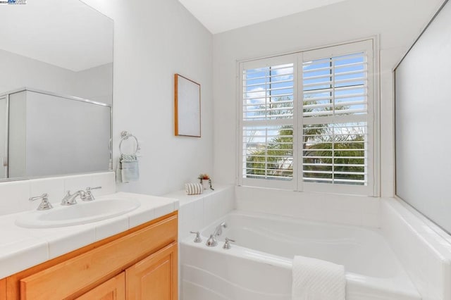 bathroom with a healthy amount of sunlight, a bathtub, and vanity