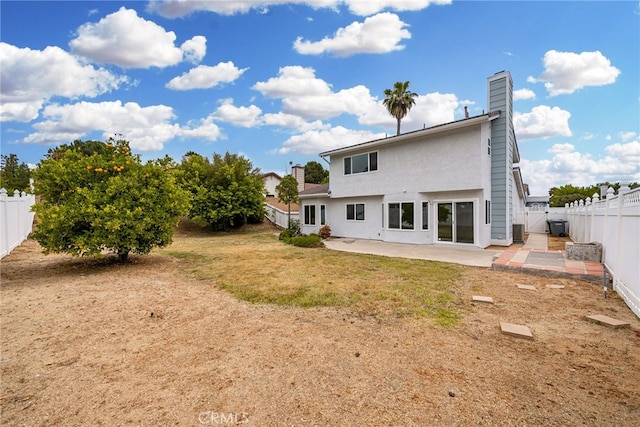 back of house with a patio area, a lawn, and central AC