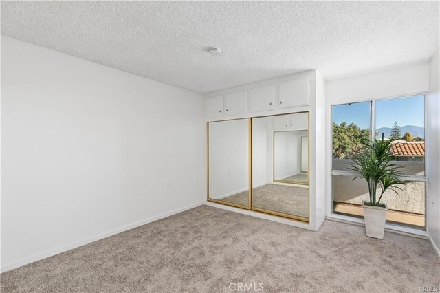 carpeted bedroom featuring a textured ceiling and a closet