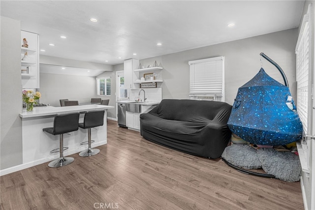 living room with light wood-type flooring and sink