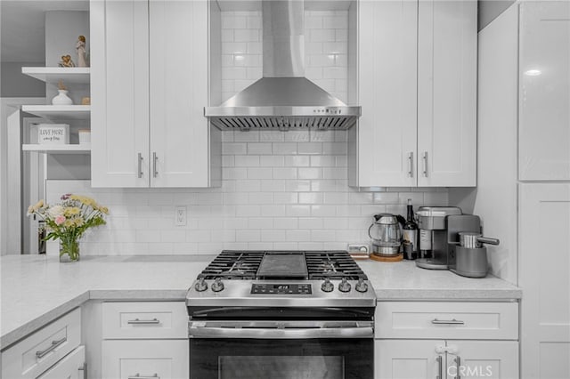 kitchen featuring white cabinets, wall chimney exhaust hood, and stainless steel range with gas stovetop