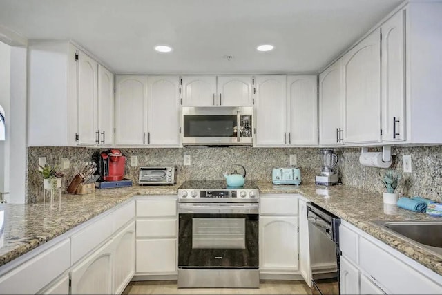 kitchen featuring backsplash, stainless steel appliances, and white cabinetry