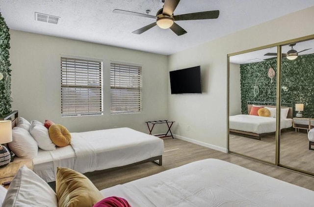 bedroom with ceiling fan, a closet, and hardwood / wood-style flooring