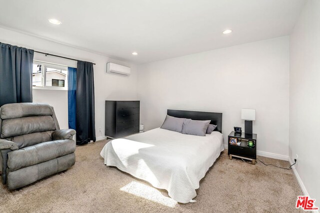 bedroom featuring a wall unit AC and light carpet