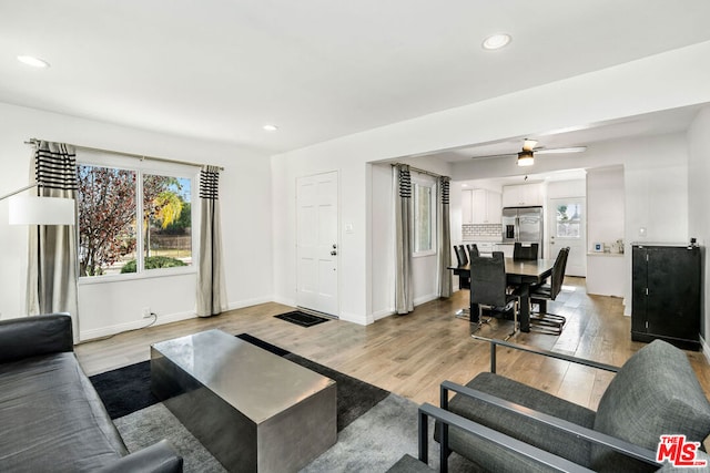 living room with ceiling fan and light hardwood / wood-style flooring