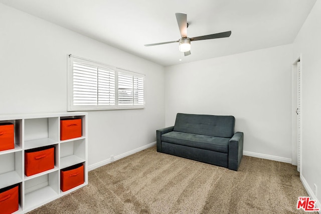 sitting room with ceiling fan and carpet