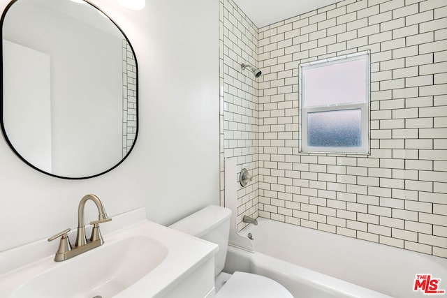 full bathroom featuring toilet, tiled shower / bath combo, and vanity