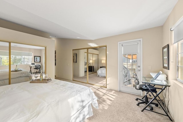 bedroom with light carpet and two closets