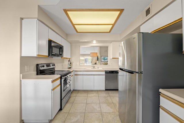 kitchen with light tile patterned floors, white cabinets, appliances with stainless steel finishes, and sink