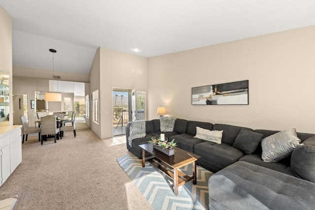 living room with a high ceiling and light colored carpet