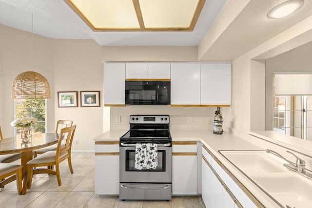 kitchen featuring white cabinets, electric range, sink, and light tile patterned flooring