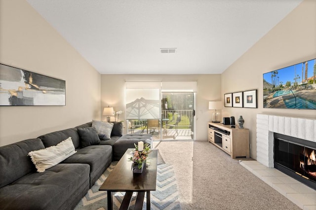 carpeted living room with a tile fireplace