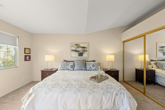 carpeted bedroom featuring vaulted ceiling and a closet