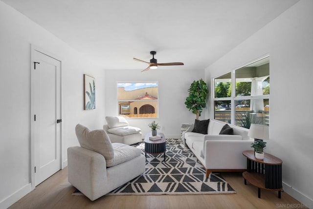 living room with ceiling fan and light hardwood / wood-style flooring